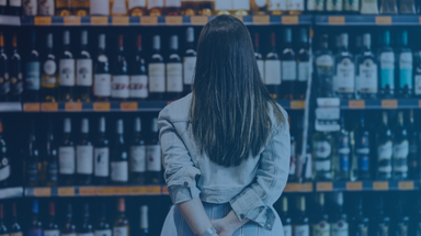 Woman customer looking at a rack of wine in supermarket